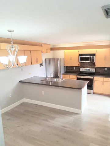 a kitchen with stainless steel appliances granite countertop a sink and a stove