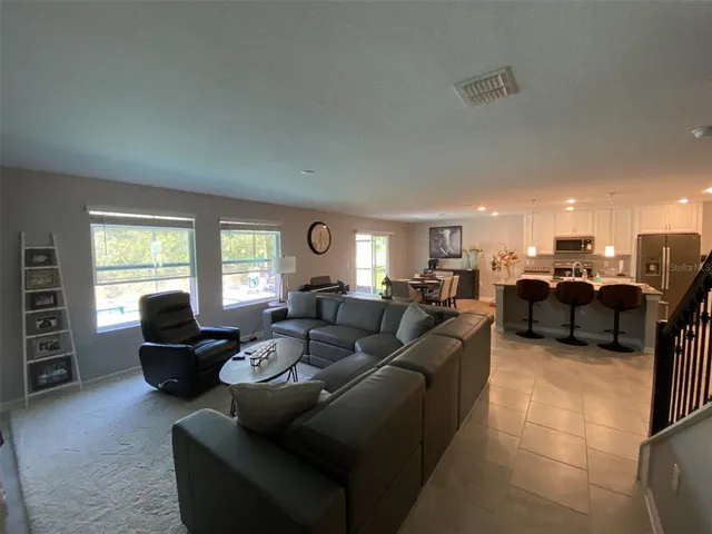 a kitchen with stainless steel appliances granite countertop a refrigerator a stove a sink dishwasher and white cabinets with wooden floor