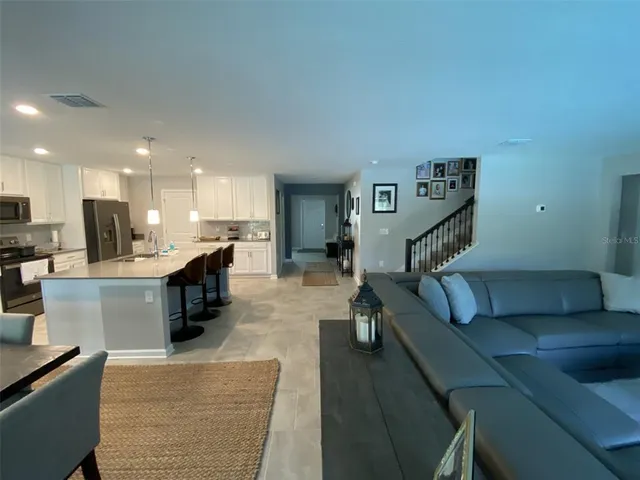a living room with furniture and a view of kitchen