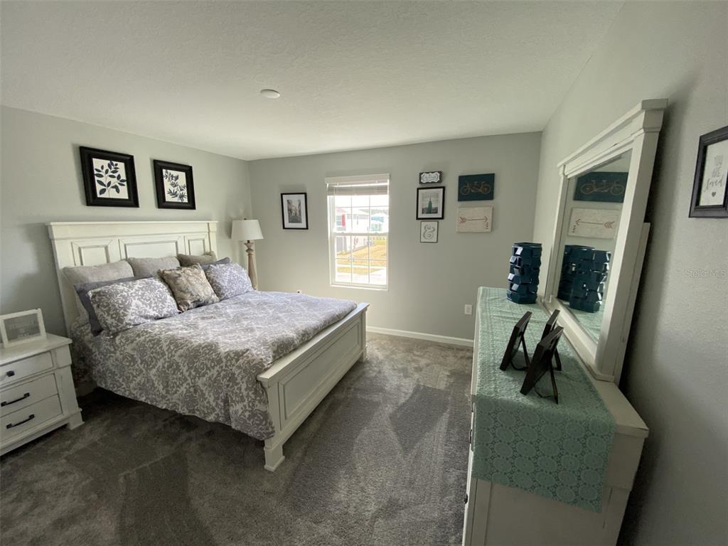 5686 Alenlon Way Mount Dora, FL 32757 - Photo 33 of 62 a bedroom with a bed a couch and dresser