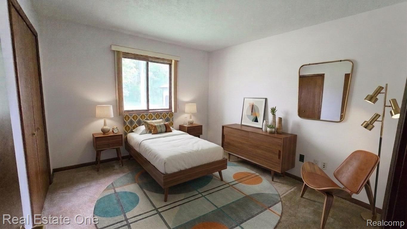 8950 Wise Road Commerce Township, MI 48382 - Photo 10 of 39 Spacious bedroom featuring light-colored walls, a window with exterior views, and a closet with wood-finish bi-fold doors