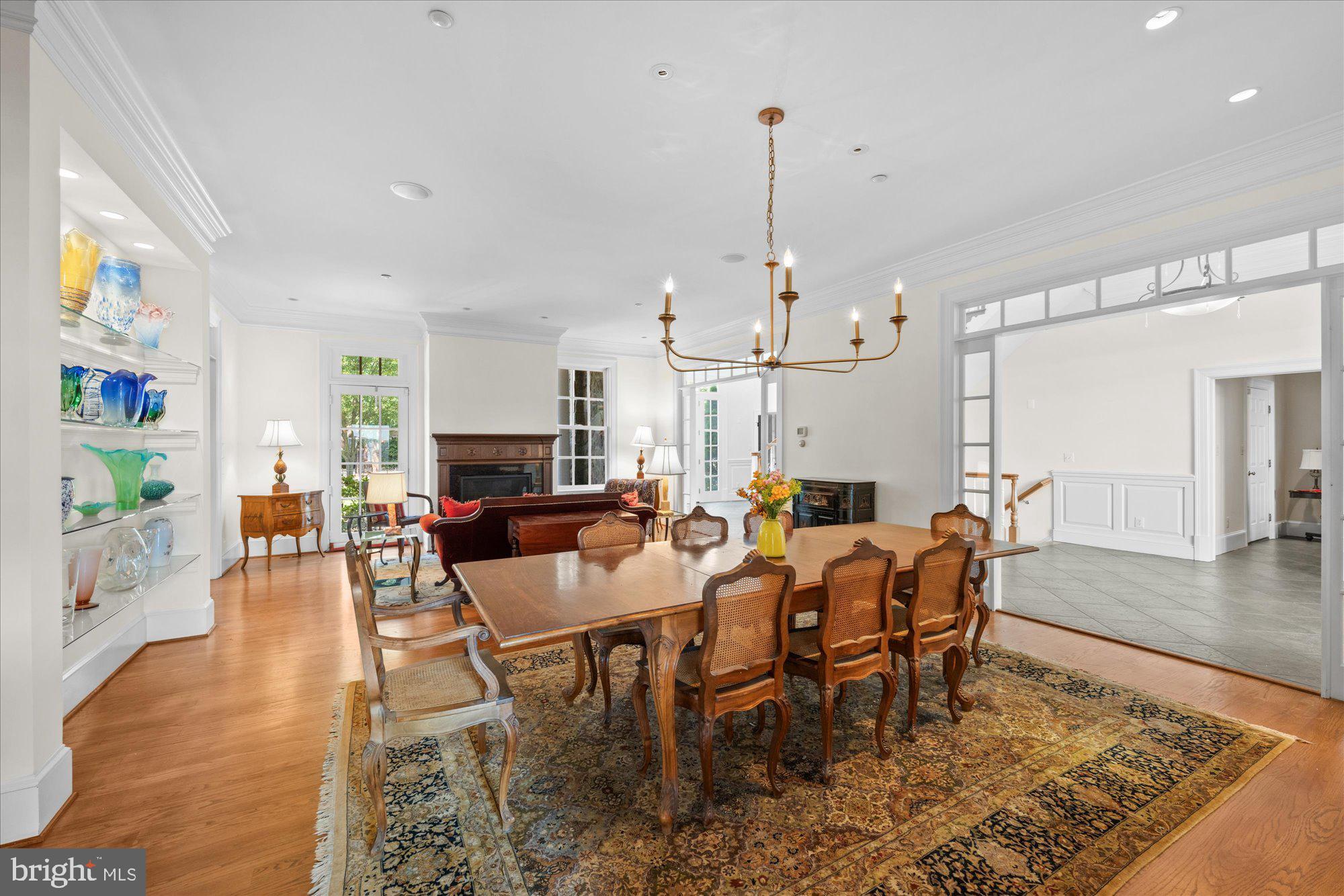 1701 South Arlington Ridge Road Arlington, VA 22202 - Photo 35 of 90 a view of a dining room and livingroom with furniture wooden floor a rug a flat screen tv a rug and a chandelier