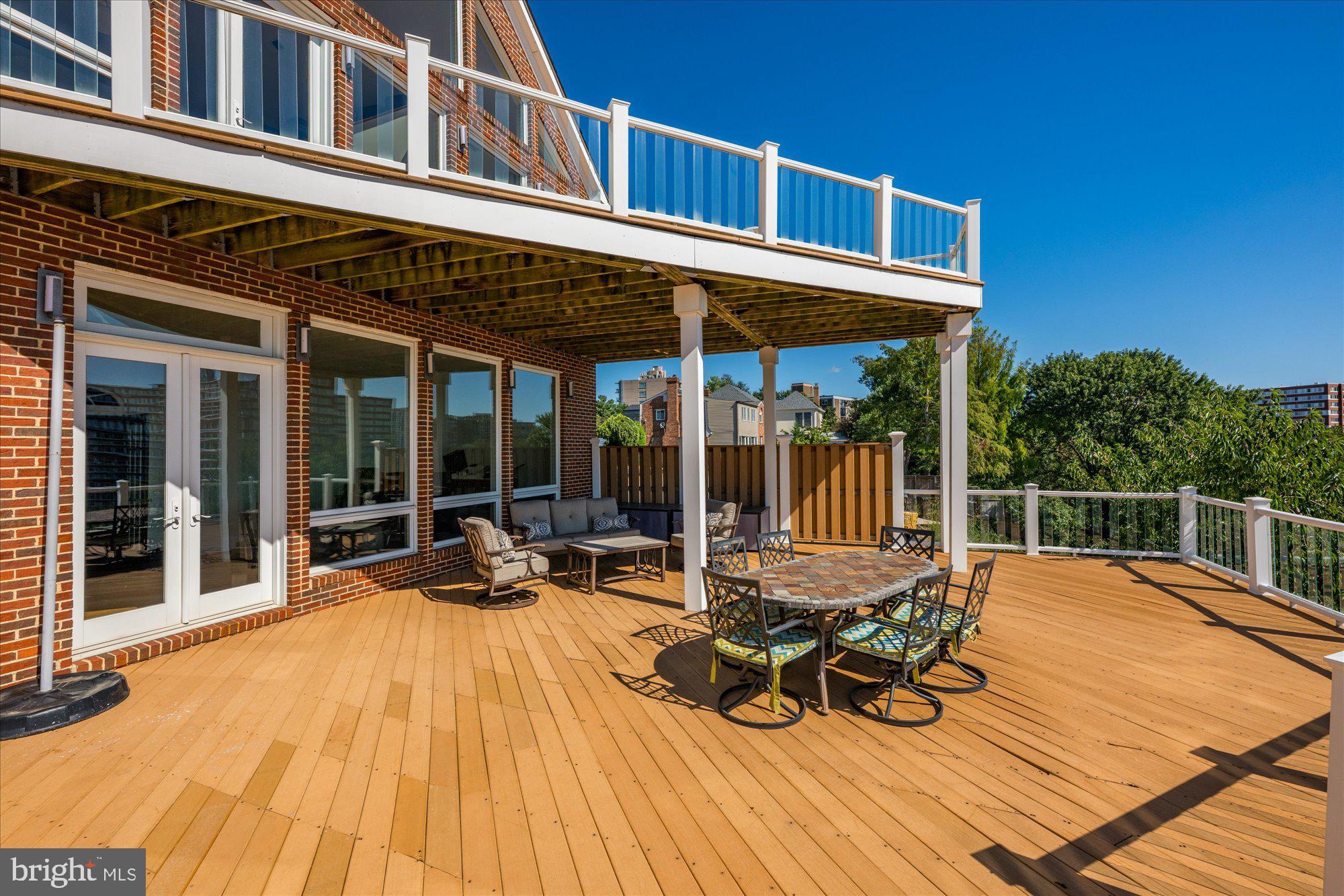 1701 South Arlington Ridge Road Arlington, VA 22202 - Photo 40 of 90 a view of a patio with table and chairs floor to ceiling window with wooden floor