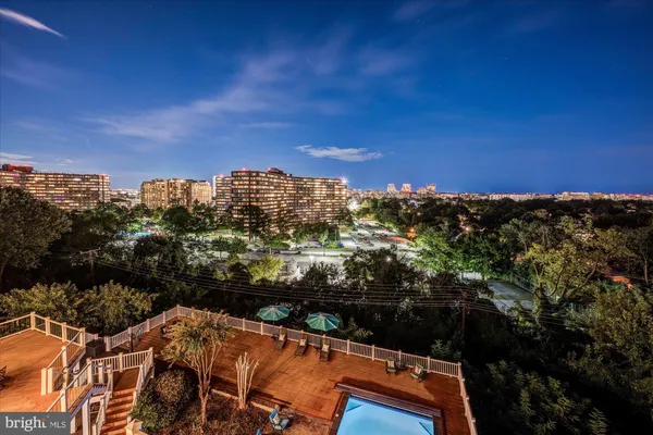 a living room with furniture kitchen view and large windows