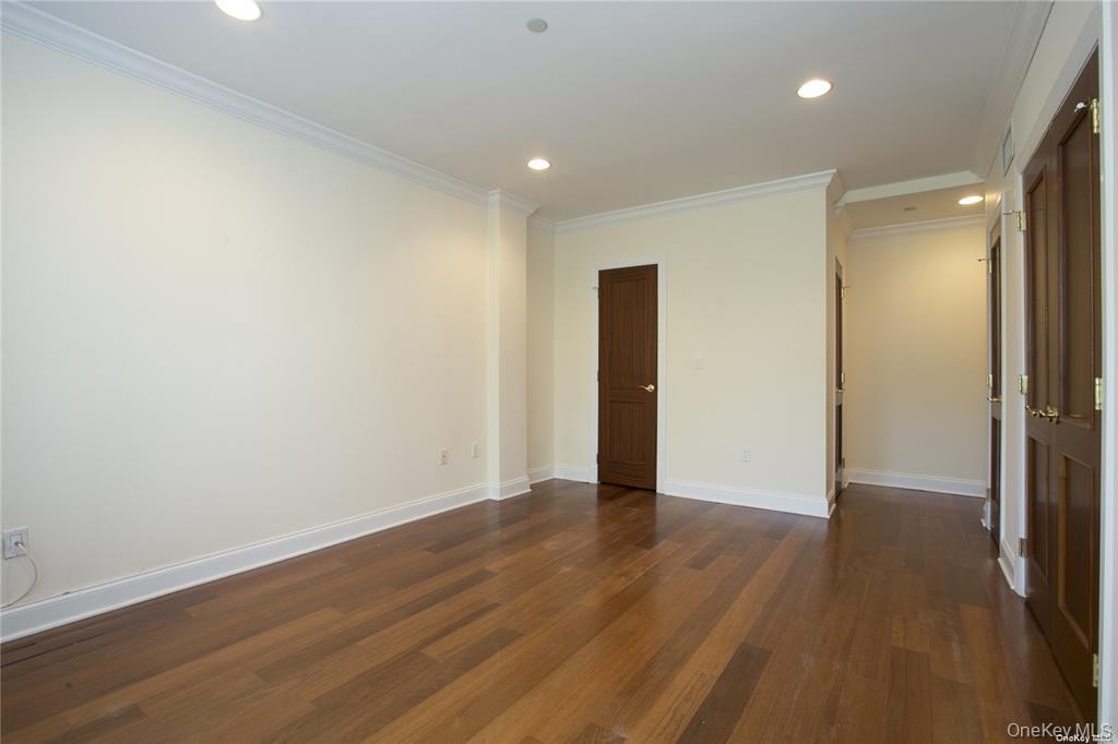 171 Great Neck Road, Unit 1N Great Neck, NY 11021 - Photo 12 of 15 Empty room with recessed lighting, dark wood finished floors, and ornamental molding
