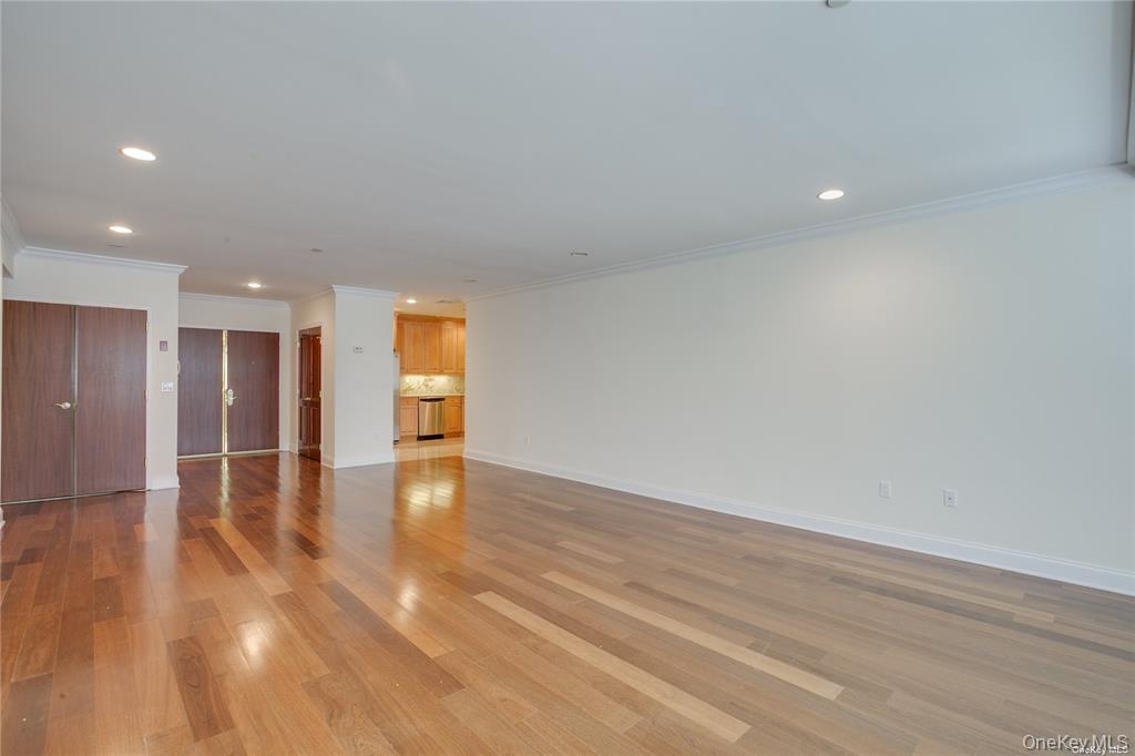 171 Great Neck Road, Unit 1N Great Neck, NY 11021 - Photo 5 of 15 Unfurnished living room with crown molding, wood finished floors, and recessed lighting