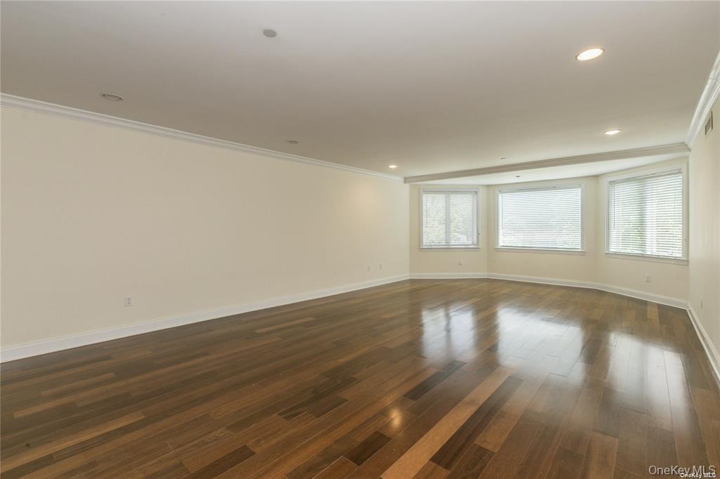171 Great Neck Road, Unit 1N Great Neck, NY 11021 - Photo 6 of 15 Empty room with crown molding, dark wood finished floors, and recessed lighting