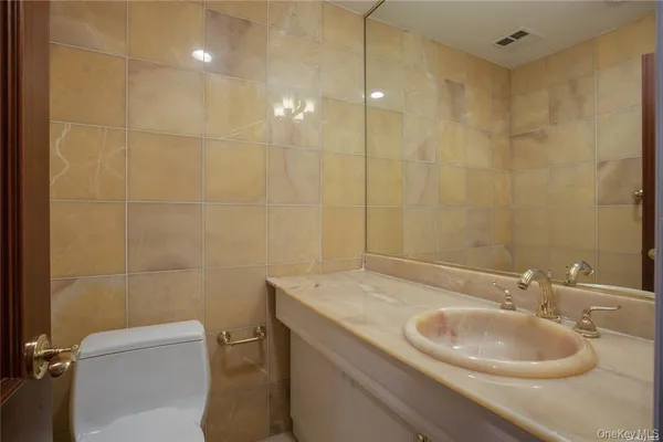 a bathroom with a sink a toilet and a mirror