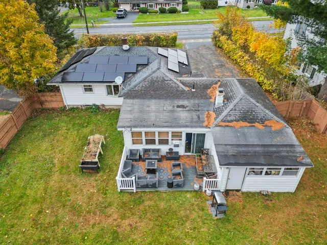an aerial view of a house with swimming pool and large trees
