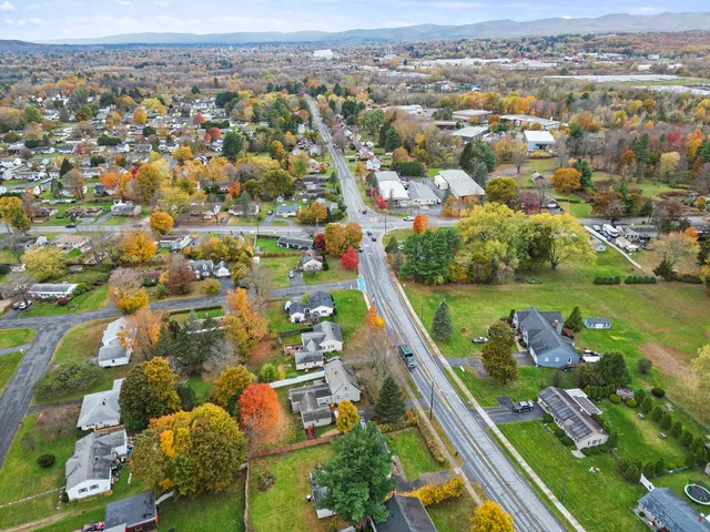 an aerial view of residential houses with outdoor space and trees