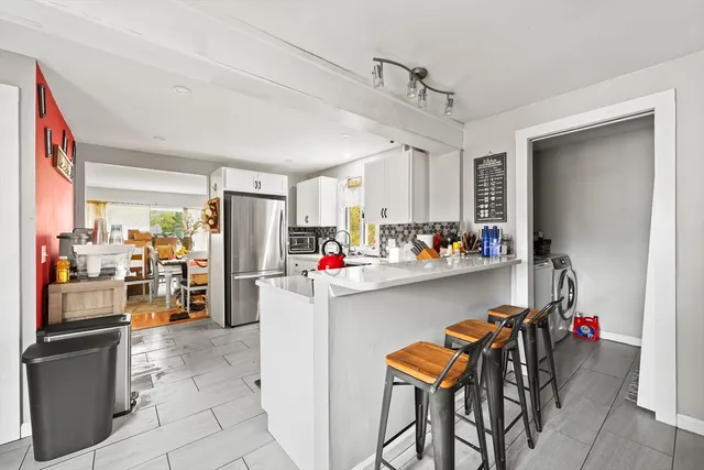 a view of a dining room with furniture and a kitchen