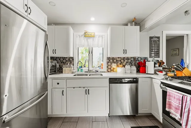 a kitchen with white cabinets and white appliances