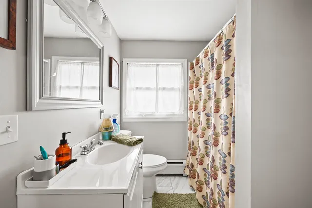 a white bath tub sitting next to a white sink and a window