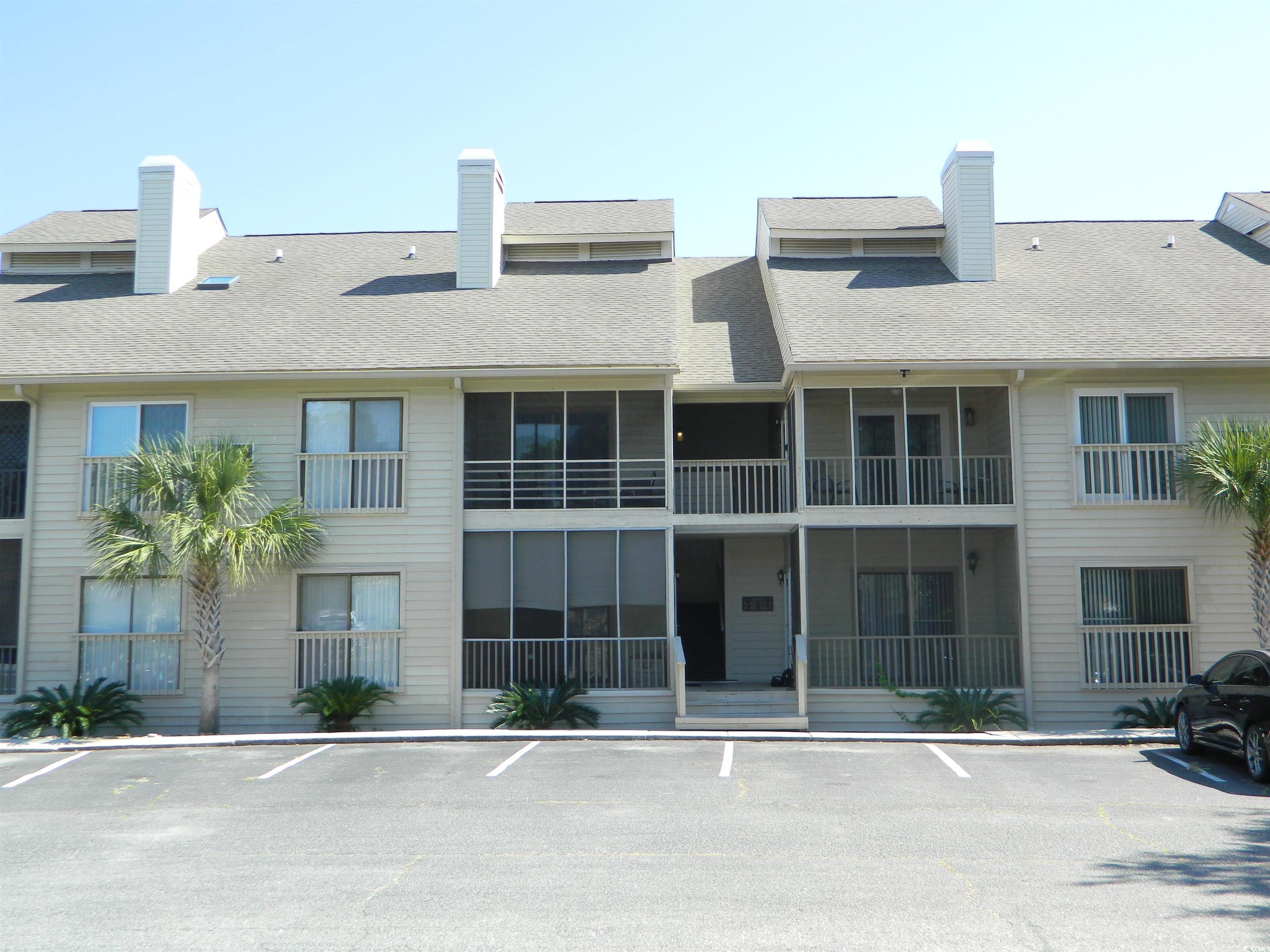 1356 Glenns Bay Road, Unit 103C Surfside Beach, SC 29575 - Photo 1 of 15 View of building exterior featuring uncovered parking