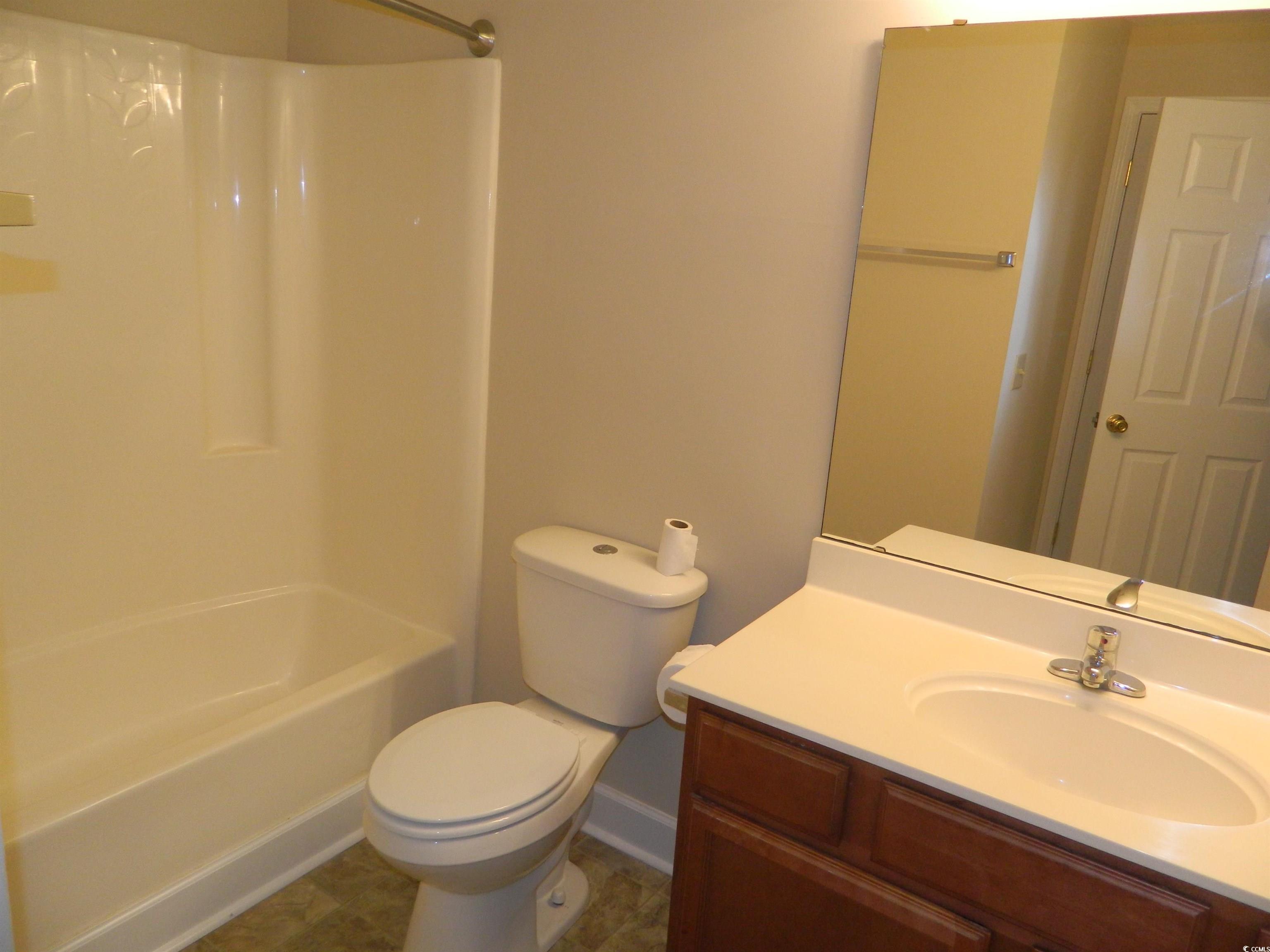 1356 Glenns Bay Road, Unit 103C Surfside Beach, SC 29575 - Photo 7 of 15 Full bath featuring vanity, bathing tub / shower combination, and dark tile patterned floors