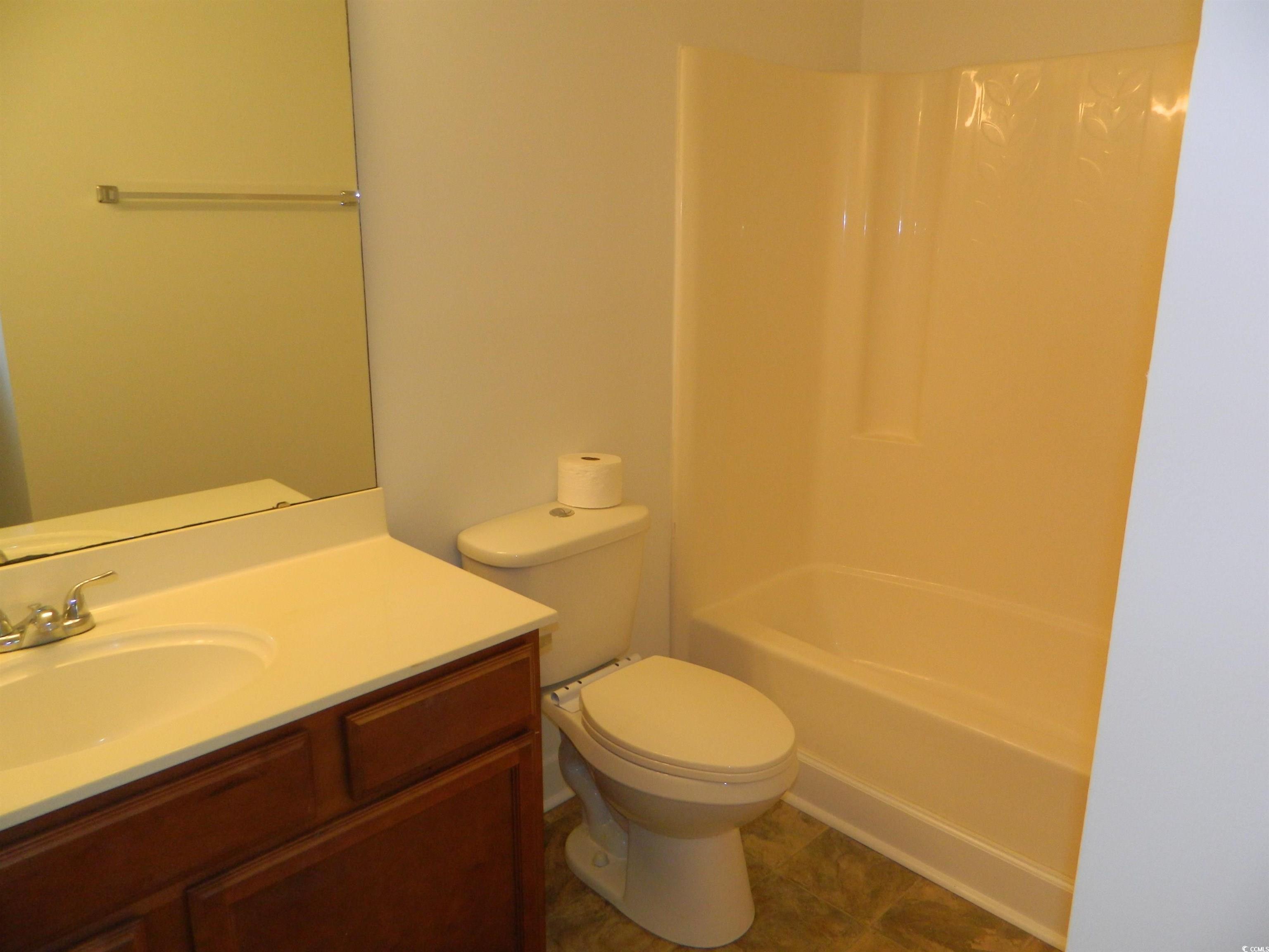 1356 Glenns Bay Road, Unit 103C Surfside Beach, SC 29575 - Photo 9 of 15 Full bath featuring vanity, bathing tub / shower combination, and dark tile patterned flooring