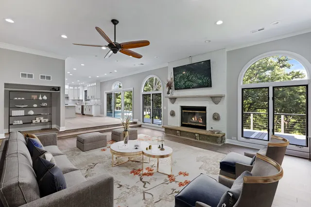 a living room with fireplace furniture and a view of kitchen