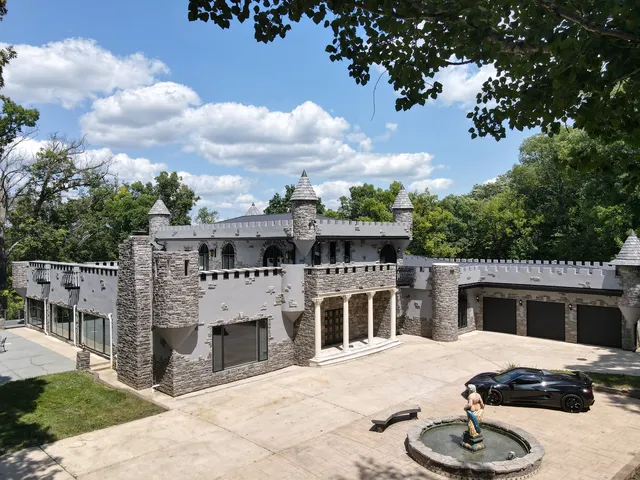an aerial view of residential house with outdoor space and trees all around