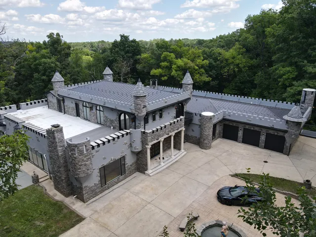an aerial view of a house with a yard and trees