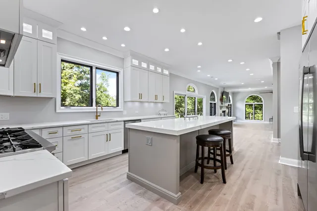 a kitchen with kitchen island white cabinets and stainless steel appliances