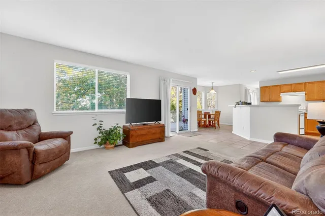 a living room with furniture a dining table and a refrigerator