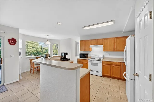 a view of kitchen with sink and refrigerator