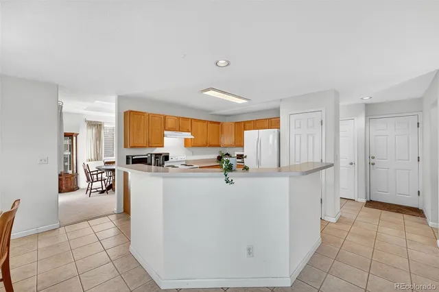 a kitchen with a sink a stove top oven a counter space and a refrigerator