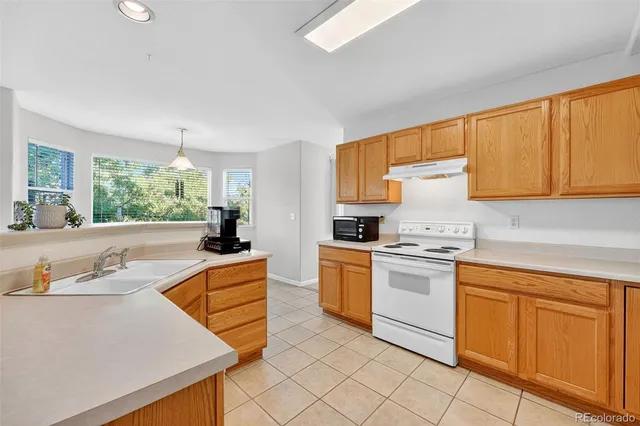 a kitchen with granite countertop cabinets and white appliances