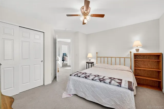an empty room with a chandelier fan and windows