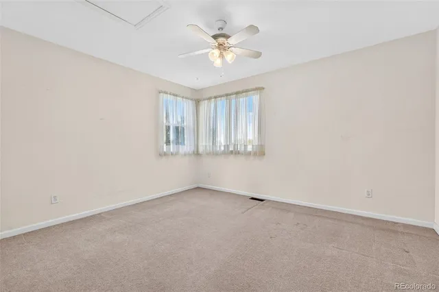 an empty room with a ceiling fan and window