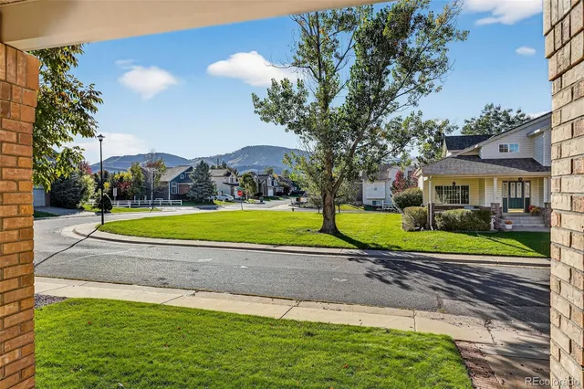 a view of a house with a big yard plants and large trees