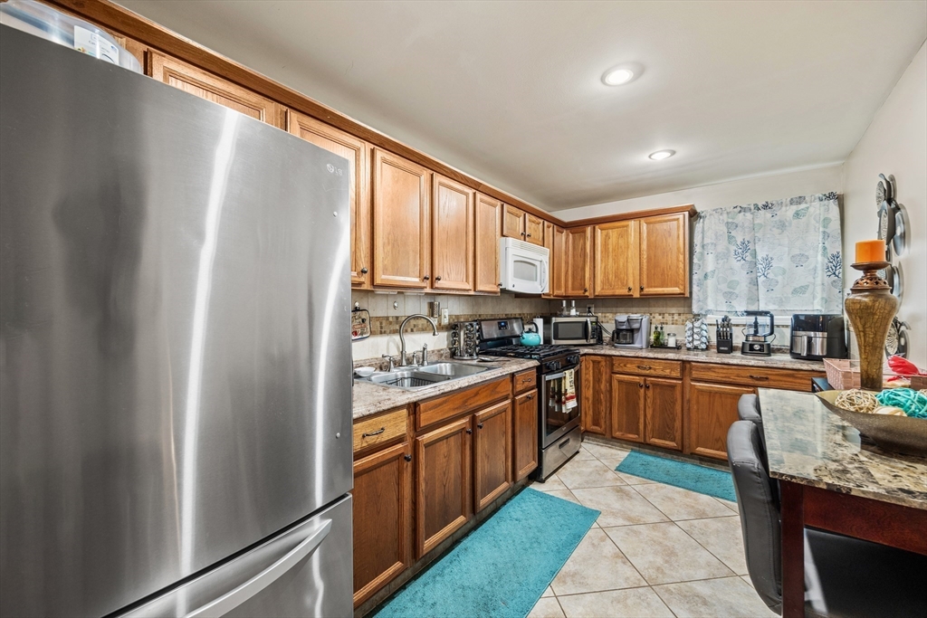 233 East Main Street Fall River, MA 02724 - Photo 5 of 29 a kitchen with stainless steel appliances granite countertop a refrigerator and a sink
