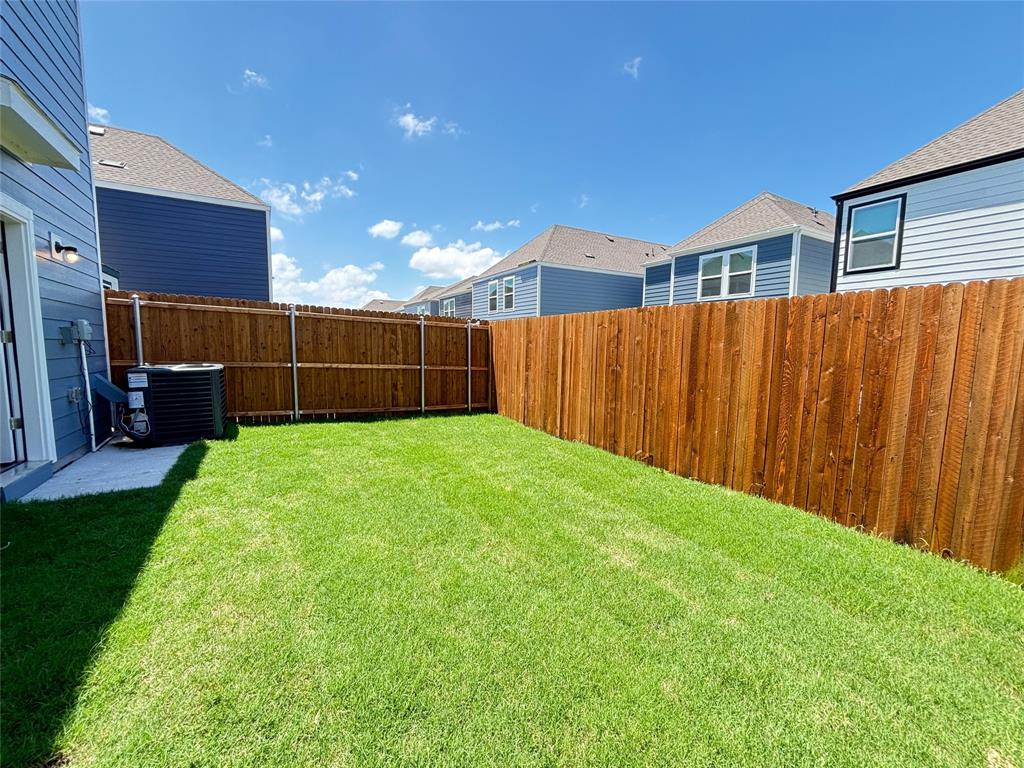 120 Redwood Road Princeton, TX 75407 - Photo 23 of 24 Fenced backyard featuring a manicured lawn, a concrete patio area, and a privacy fence constructed from vertical wood planks
