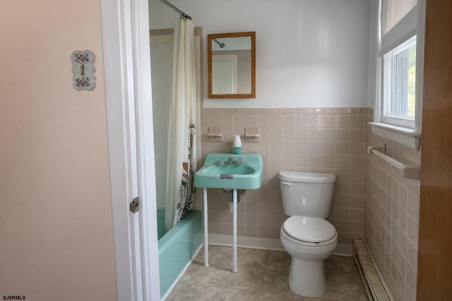 29 Summit Avenue Absecon, NJ 08201 - Photo 19 of 25 a white toilet sitting next to a bathroom sink and vanity