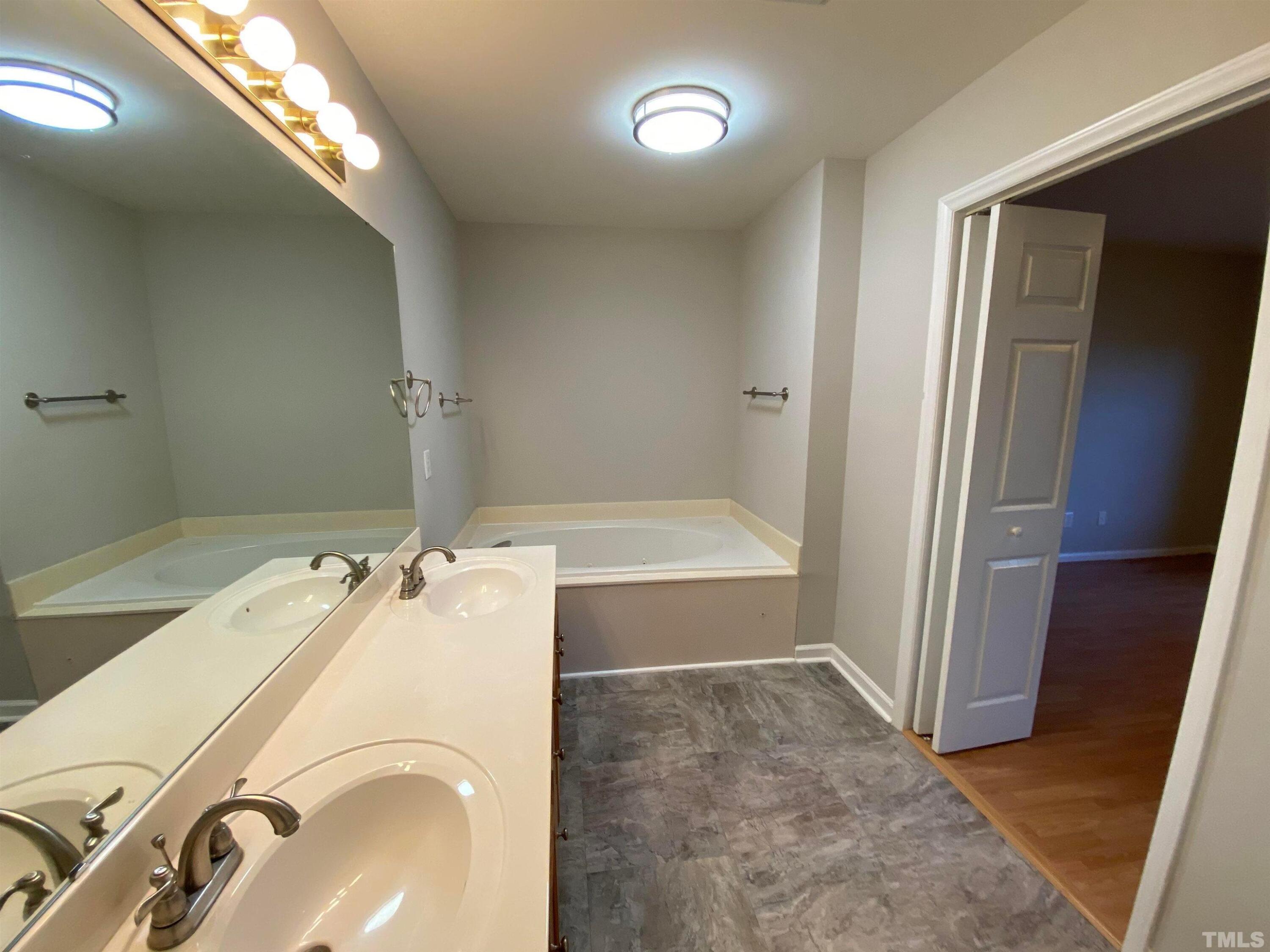 2413 Wellington Ridge Loop, Unit 2413 Cary, NC 27518 - Photo 22 of 30 a bathroom with a tub sink and a mirror