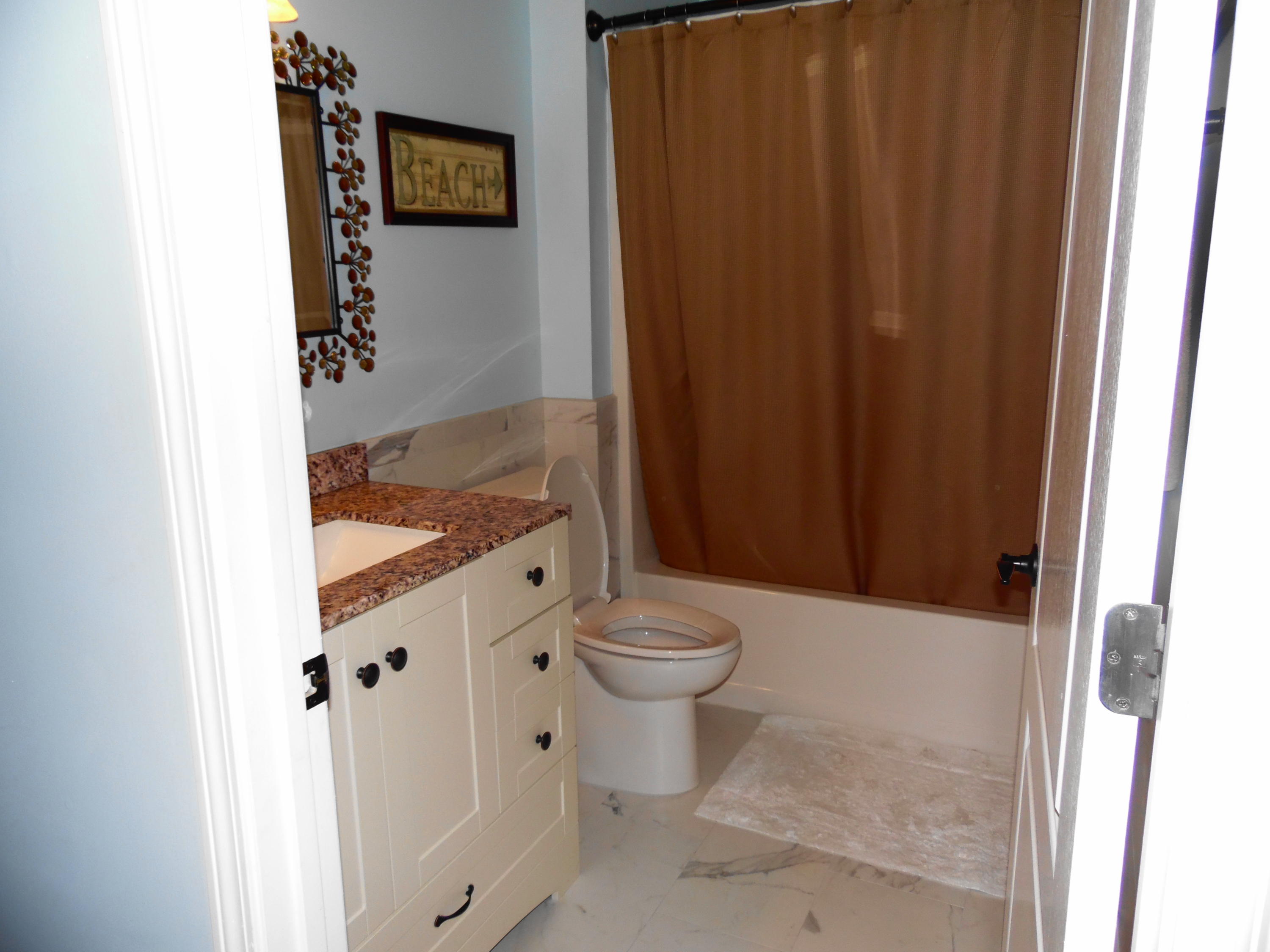 617 Tropical Way Freeport, FL 32439 - Photo 19 of 39 a bathroom with a granite countertop sink and a toilet