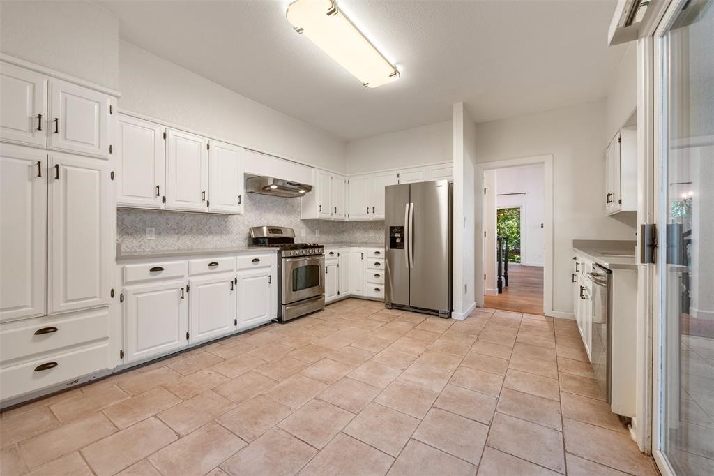 6 Sunview Road The Hills, TX 78738 - Photo 12 of 19 a kitchen with white cabinets and stainless steel appliances