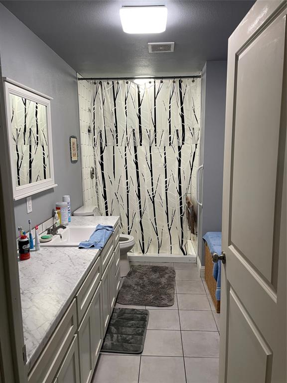 1100 East Rabbit Cove Road Quinlan, TX 75474 - Photo 16 of 18 Full bath featuring vanity, a handicap stall shower, and light tile patterned floors