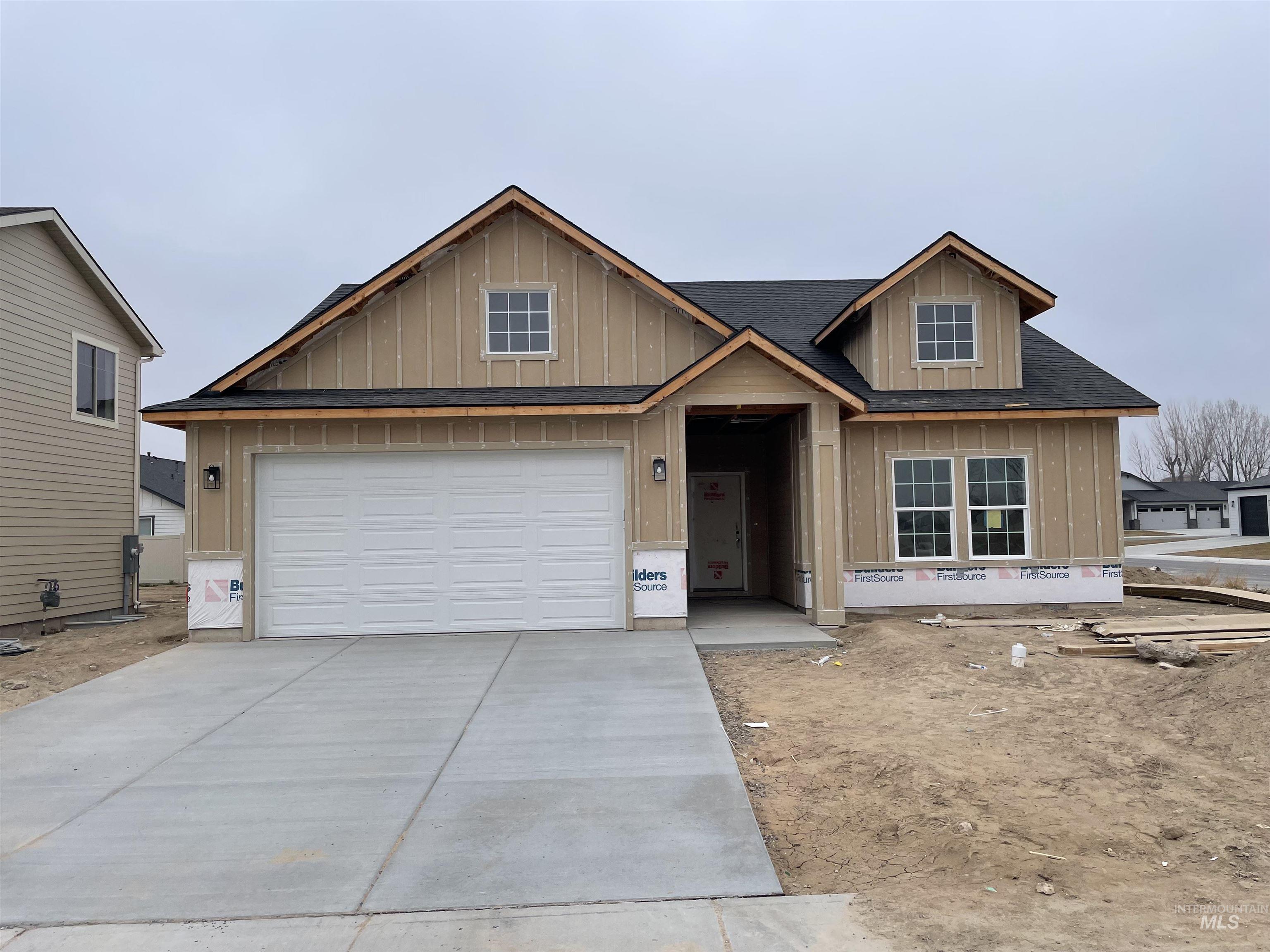 View of front of home featuring driveway, roof with shingles, board and batten siding, and a garage