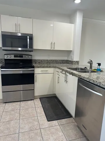 a kitchen with a stove a microwave and a sink