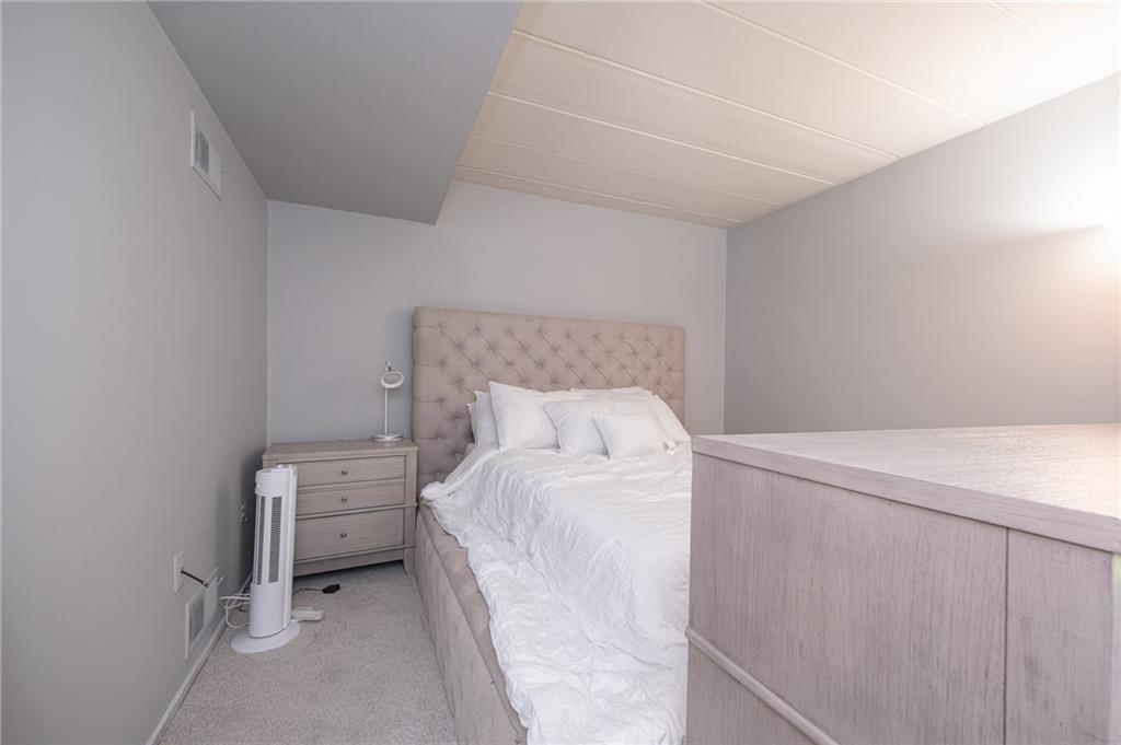 2034 Swallow Hill Road, Unit 326 Pittsburgh, PA 15220 - Photo 11 of 28 a bedroom with a bed and a lamp on the dresser