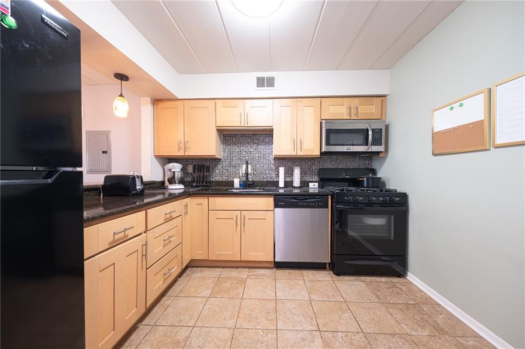 2034 Swallow Hill Road, Unit 326 Pittsburgh, PA 15220 - Photo 3 of 28 a kitchen with stainless steel appliances granite countertop a stove a sink and a microwave