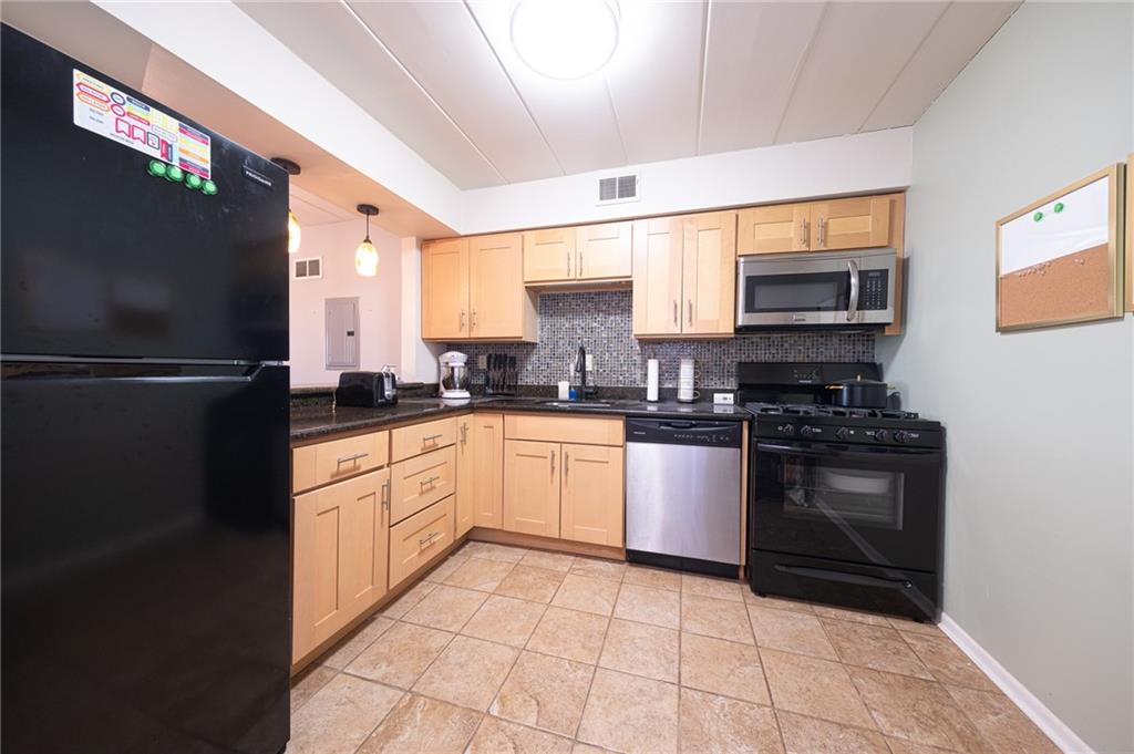 2034 Swallow Hill Road, Unit 326 Pittsburgh, PA 15220 - Photo 4 of 28 a kitchen with granite countertop a refrigerator stove and microwave