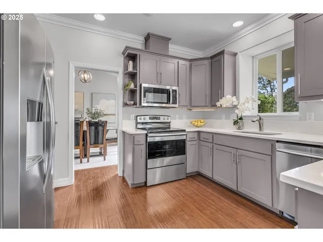 a kitchen with stainless steel appliances granite countertop a sink stove and cabinets