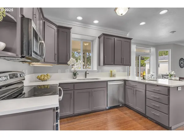 a kitchen with appliances a sink cabinets and a counter top space