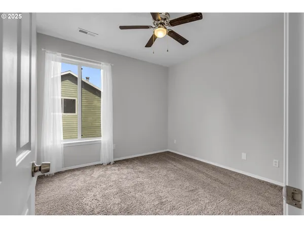 a spacious bathroom with a granite countertop sink a toilet and a mirror