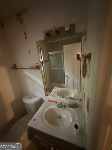 a bathroom with a sink and mirror with toilet
