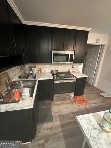 a kitchen with stainless steel appliances kitchen island granite countertop a refrigerator and a stove top oven