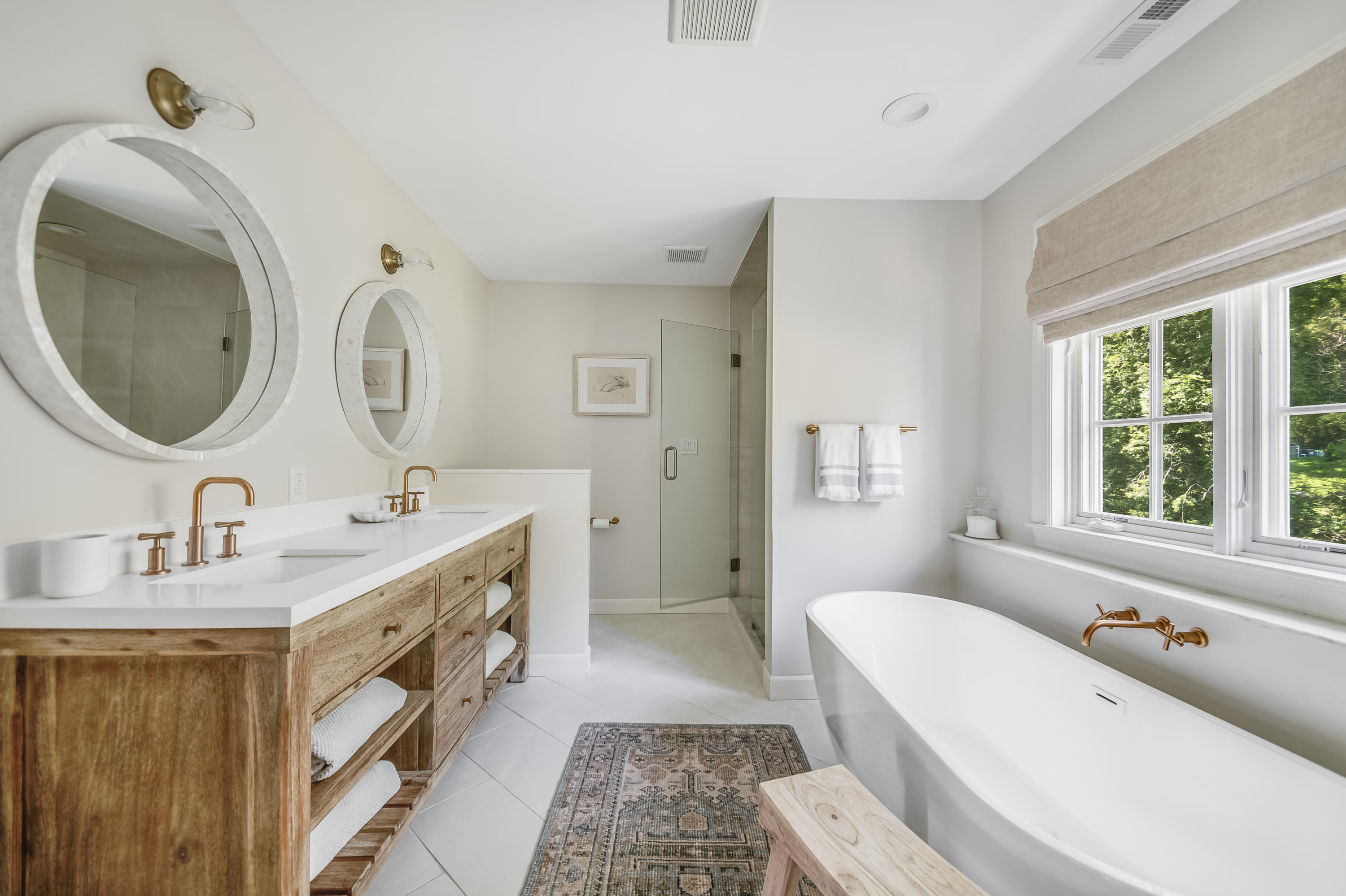 155 Hillcrest Road New Canaan, CT 06840 - Photo 22 of 32 a spacious bathroom with a double vanity sink a two mirror a window and a bathtub
