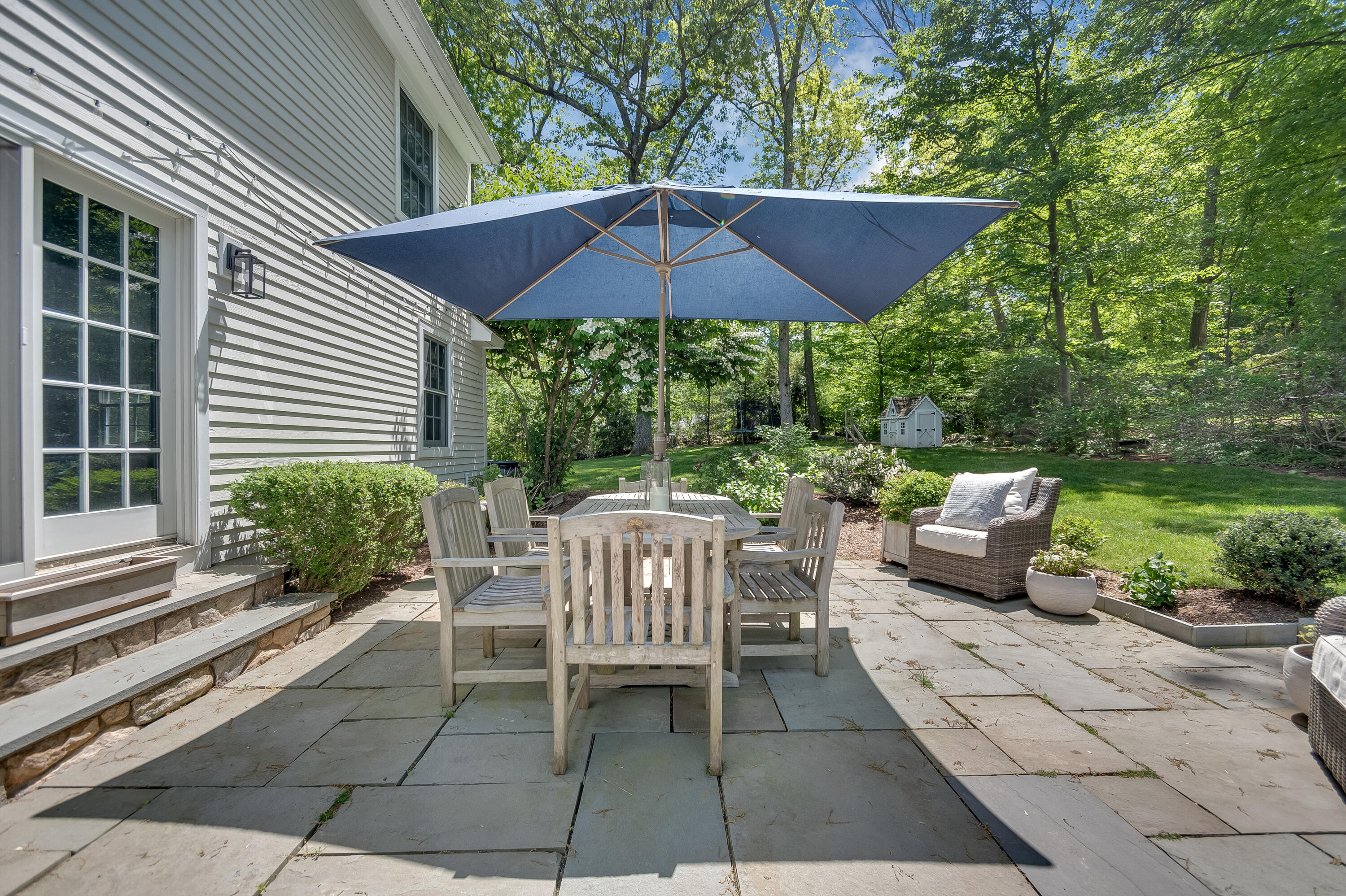 155 Hillcrest Road New Canaan, CT 06840 - Photo 29 of 32 a view of a patio with a table and chairs under an umbrella